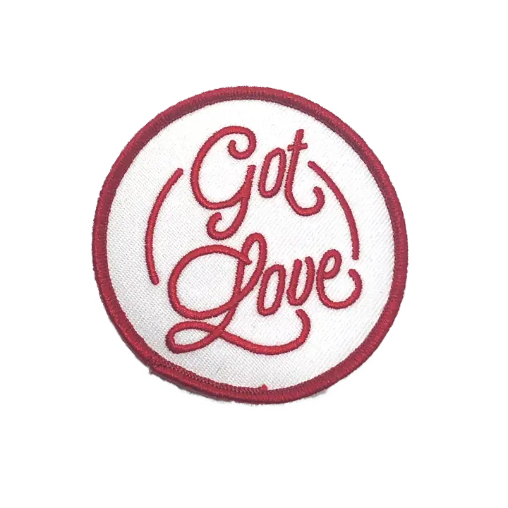 Circular patch with ’Got Love’ embroidered in red cursive text on a white background.