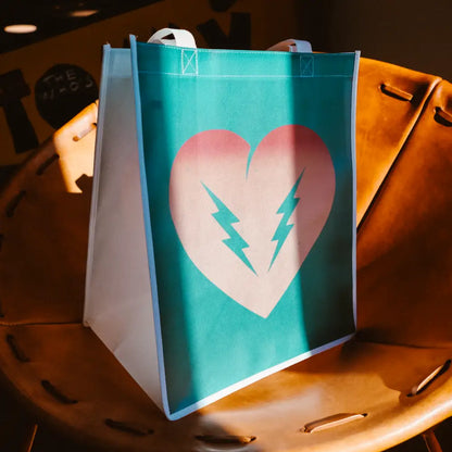 Teal reusable shopping bag with a pink heart and lightning bolt design.