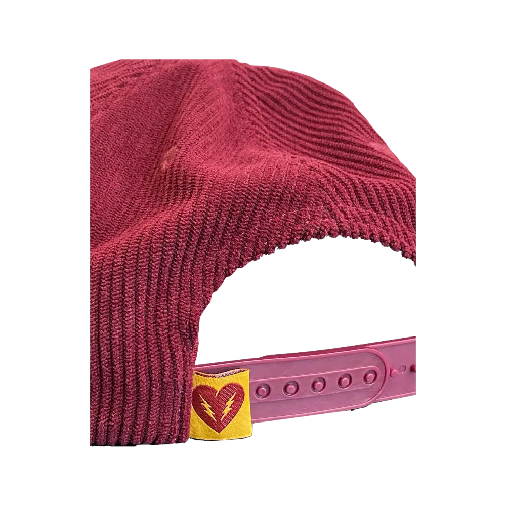 Burgundy corduroy baseball cap with a yellow heart logo on the adjustable strap.