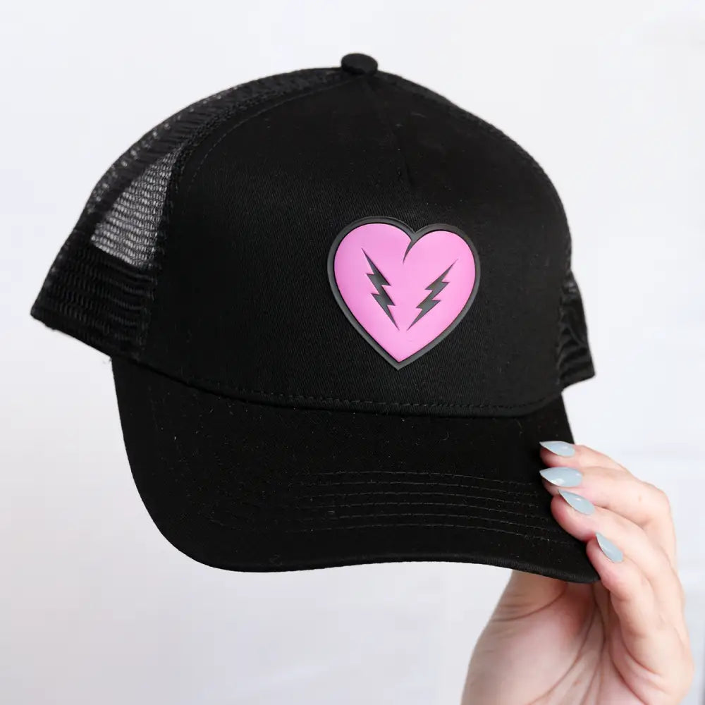 Black trucker hat with pink heart and lightning bolts.