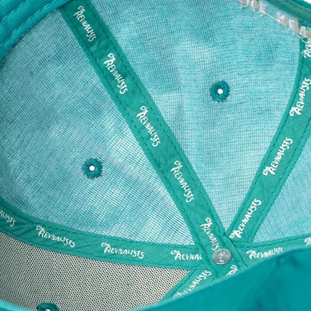 Teal baseball-style cap with mesh panels and a branded interior band.