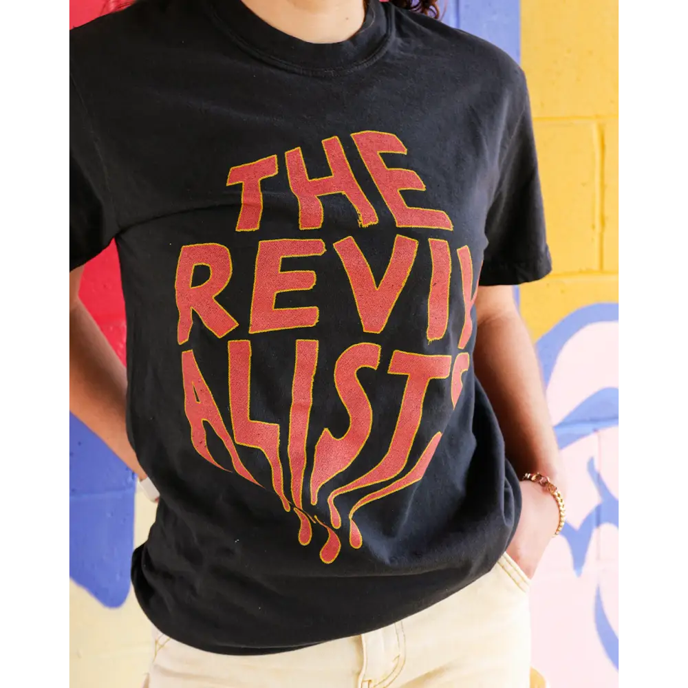 Black t-shirt with ’THE REVIVALIST’ printed in orange-red melting text.