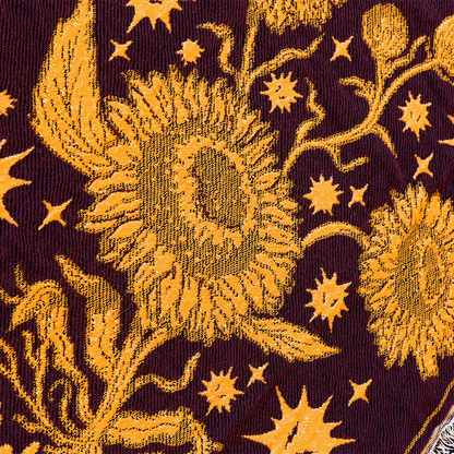 The Revivalists woven blanket is a deep burgundy woven blanket with bold golden-yellow sunflowers and stars pattern